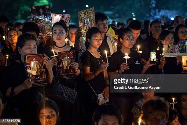 People holds candles at Sanam Luang front of the Grand Palace to pay homage for the late King Bhumibol Adulyadej on his 89th birthday. This day mark...