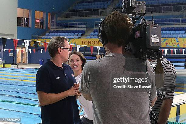 Penny Oleksiak photobombs her coach Ben Titley as he does an interview on deck as she prepares for the world short course championships in Windsor,...
