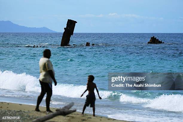 Local people play near debris of the Japanese Imperial Navy transport vessel Kinugawa Maru at Tassafaronga beach on September 3, 2016 in Guadalcanal...