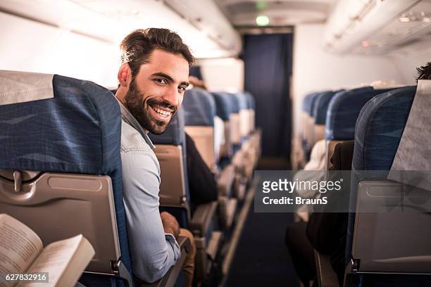 joven pasajero feliz volando en el avión. - passenger fotografías e imágenes de stock