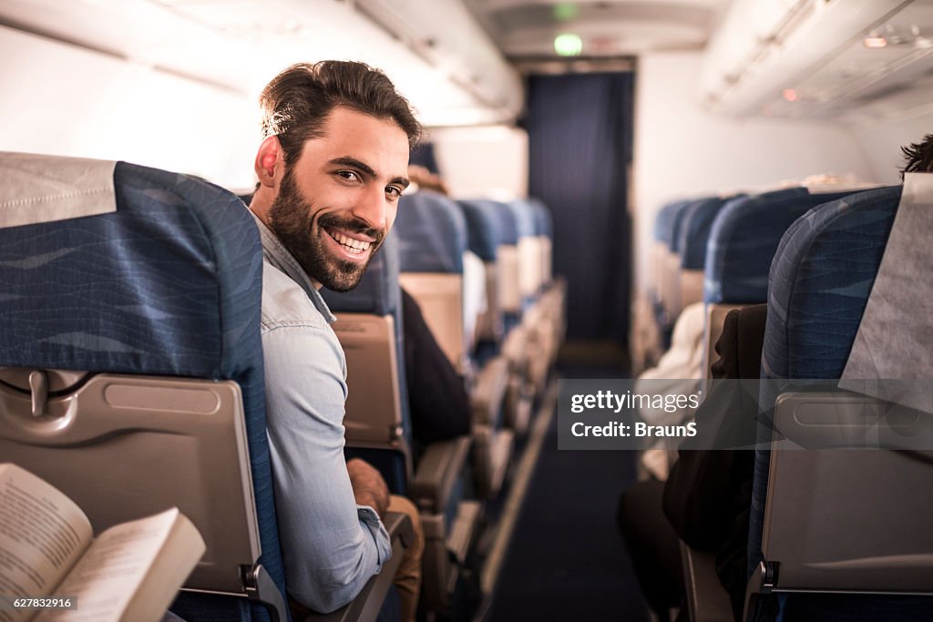 Young happy passenger flying in the airplane.