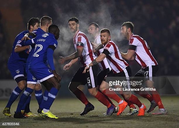 Alan Power, Luke Waterfall an Jamie McCombe of Lincoln City prepare for a corner during the Emirates FA Cup Second Round match between Lincoln City...