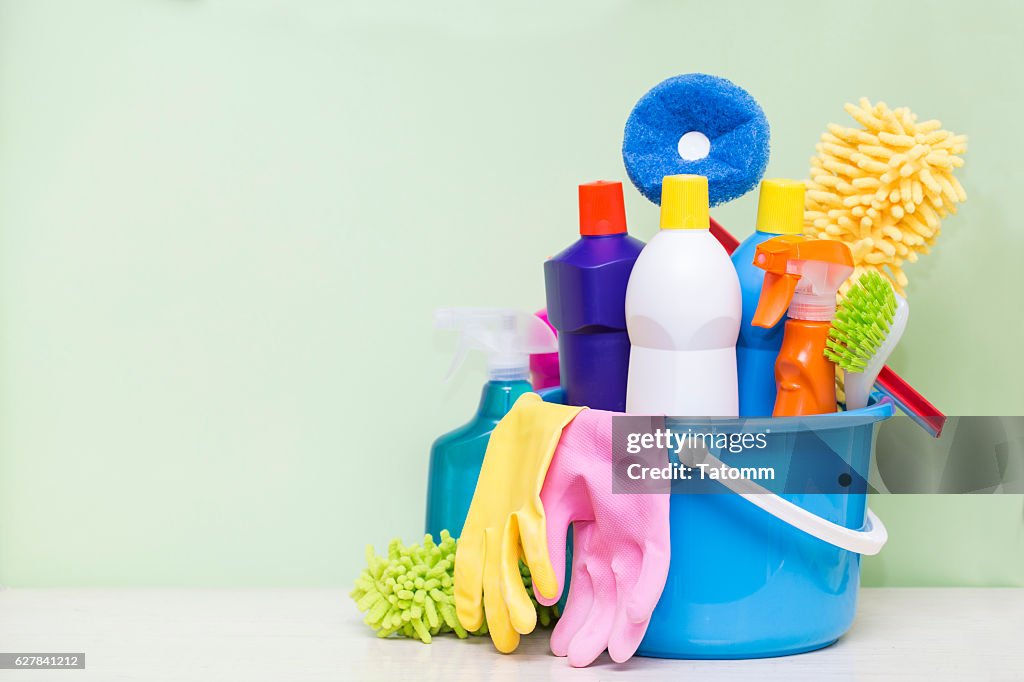 House cleaning product on wood table with green background
