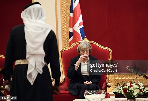 British Prime Minister Theresa May drinks tea with Khalifa bin Salman Al Khalifa, the Prime Minister of Bahrain, as she arrives at Sakhir Airbase on...