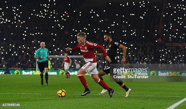 Viktor Fischer of Middlesbrough is chased by Ahmed Elmohamady of Hull City as fans light up the stadium during the Premier League match between...
