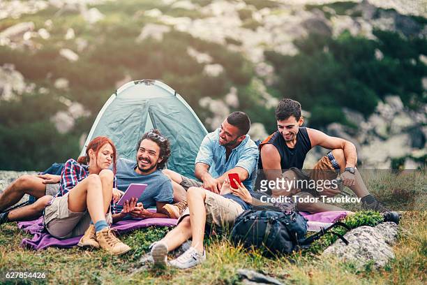 friends browsing the net in the mountain - camping friends stock pictures, royalty-free photos & images