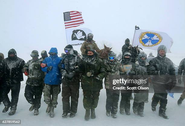 Despite blizzard conditions, military veterans march in support of the "water protectors" at Oceti Sakowin Camp on the edge of the Standing Rock...