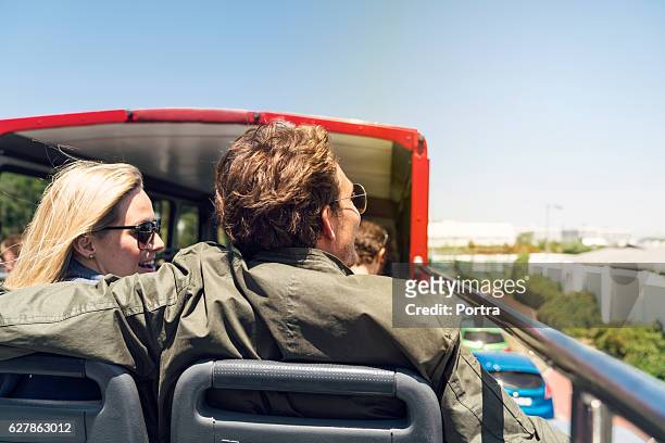 rear view of couple traveling in open-air bus - tourist bus stock pictures, royalty-free photos & images
