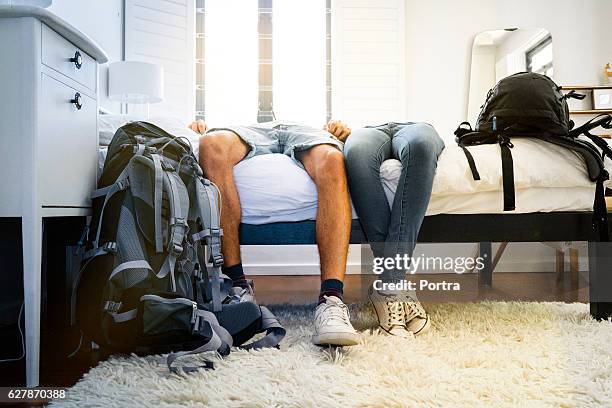 low section of tired couple resting on bed - destination fashion 2016 stock pictures, royalty-free photos & images