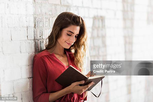 smiling businesswoman writing in diary at office - writing stock pictures, royalty-free photos & images