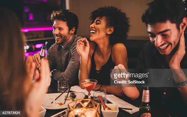 friends enjoying a meal - evening meal restaurant stock pictures, royalty-free photos & images