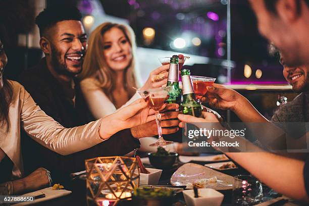 here's to the new year! - friends in restaurant bar stockfoto's en -beelden