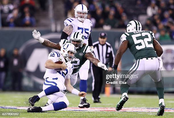 Andrew Luck of the Indianapolis Colts slides down against the defense of Leonard Williams and David Harris of the New York Jets in the first quarter...