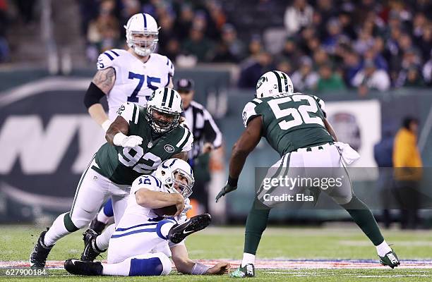 Andrew Luck of the Indianapolis Colts slides down against the defense of Leonard Williams and David Harris of the New York Jets in the first quarter...