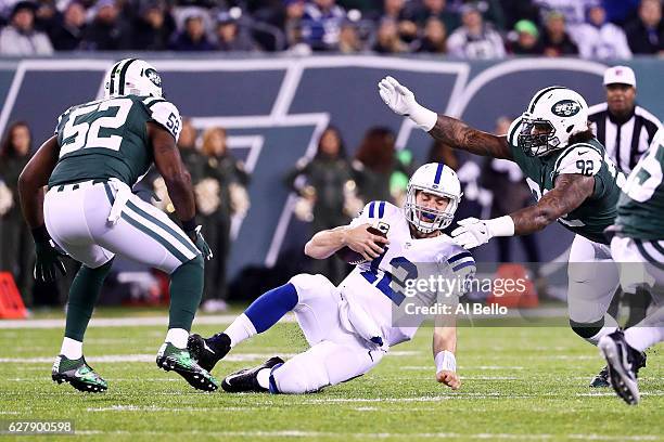 Andrew Luck of the Indianapolis Colts slides down against the defense of Leonard Williams and David Harris of the New York Jets in the first quarter...