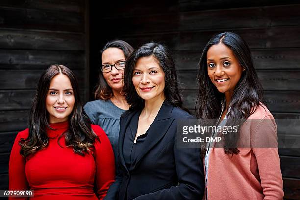 group of businesswomen standing together in office - four people stock pictures, royalty-free photos & images