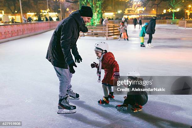 bambini che imparano a pattinare sul ghiaccio - pista di pattinaggio su ghiaccio foto e immagini stock