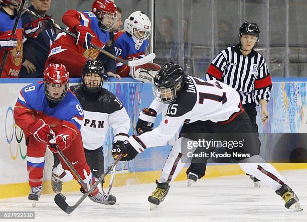 Russia - Japan forward Rui Ukita and Russia forward Alexandra Vafina fight for the puck during the first period of a Group B preliminary game in the...