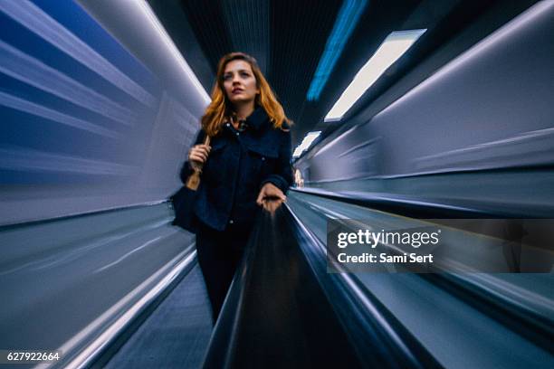 businesswoman standing at escalator - disembarking train stock pictures, royalty-free photos & images