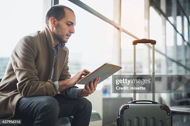 young man waiting for flight - airport terminal stock pictures, royalty-free photos & images