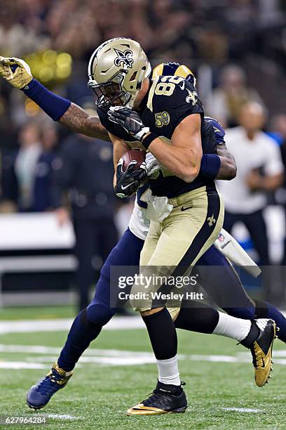 Coby Fleener of the New Orleans Saints catches a pass in the first half over Mark Barron of the Los Angeles Rams at Mercedes-Benz Superdome on...