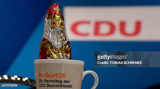 Chocolate Santa Claus sticks in a mug at one of the delegate's places prior to the start of the conservative Christian Democratic Union party's...