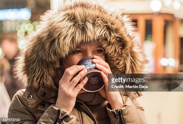 woman with glogg at christmas market - glögg stockfoto's en -beelden