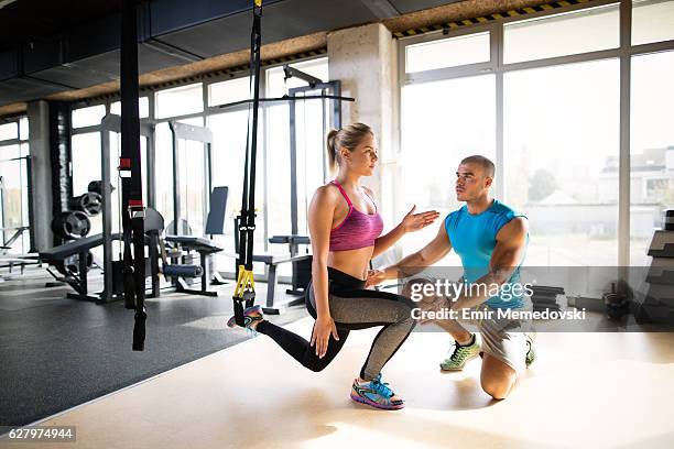 woman doing leg exercises with suspension straps  at gym. - suspension training stock pictures, royalty-free photos & images