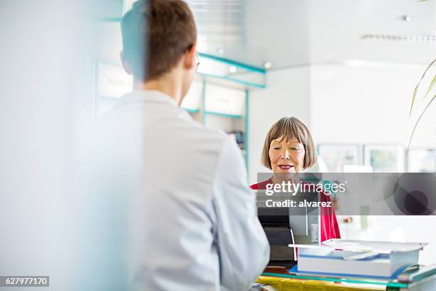 senior female customer buying medicine in pharmacy - cure berlin 2016 stockfoto's en -beelden