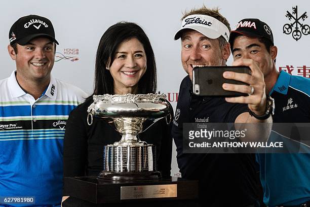 Golfers Patrick Reed of the US , Ian Poulter of Britain and Liang Wenchong of China pose in front of the Hong Kong Open golf tournament trophy after...