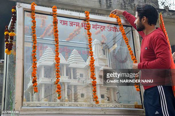Member of Hindu Bajrang Dal garlands a model of a Ram temple during a procession marking the 24th anniversary of the demolition of the Babri Masjid...