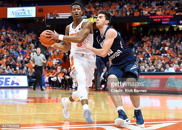 Andrew White III of the Syracuse Orange drives to the basket against the defense of Benedikt Haid of the North Florida Ospreys during the first half...