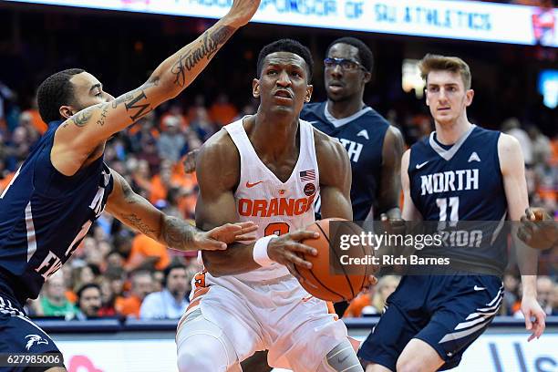 Andrew White III of the Syracuse Orange drives to the basket between a group of North Florida Ospreys defenders during the second half at the Carrier...