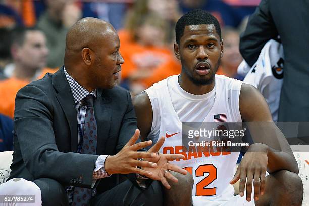 Assistant coach Adrian Autry of the Syracuse Orange talks with Taurean Thompson on the bench against the North Florida Ospreys during the second half...
