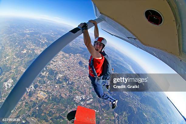 parachutist hanging out of the plane - adrenalina fotografías e imágenes de stock