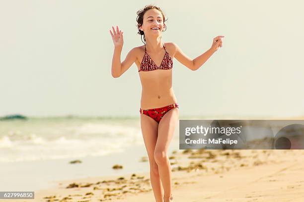 happy little girl enjoying vacations on deserted beach - tween girl swimsuit stockfoto's en -beelden