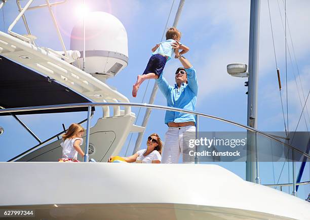 familia joven y adinerada disfrutando de las vacaciones de verano - navegación en yate fotografías e imágenes de stock