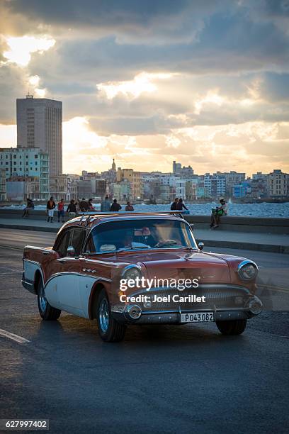 classic buick car on havana's malecon at sunset - 1950 2016 stock pictures, royalty-free photos & images