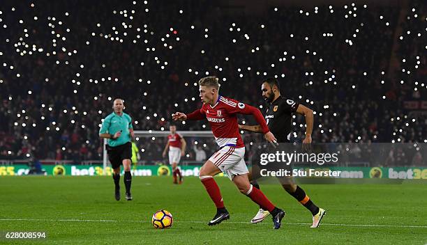 Viktor Fischer of Middlesbrough is chased by Ahmed Elmohamady of Hull City as fans light up the stadium during the Premier League match between...