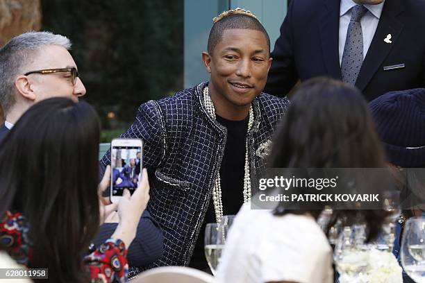 Singer Pharrell Williams presents a creation for Chanel during the 13th Métiers d'Art show on December 6, 2016 in Paris. / AFP / PATRICK KOVARIK