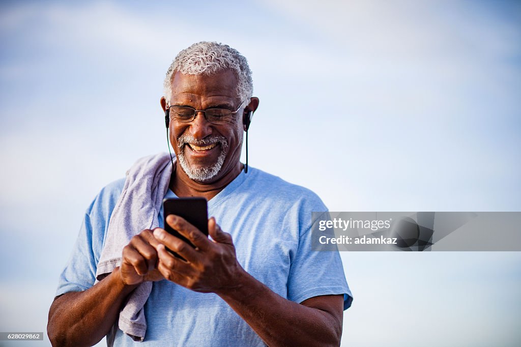 Black Man using smartphone on mountain trail