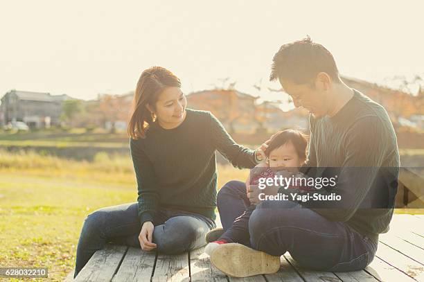 happy family having a good time with baby girl - japanese ethnicity stockfoto's en -beelden