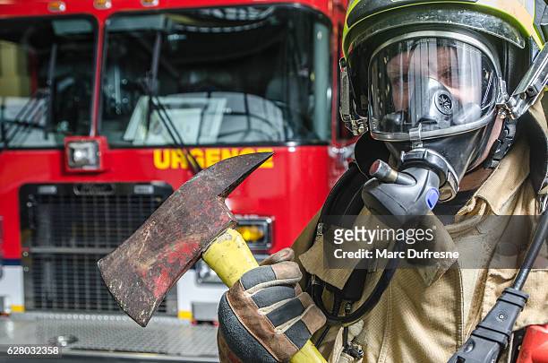 headshot on fireman wearing full protection equipment and truck - fireman axe stock pictures, royalty-free photos & images