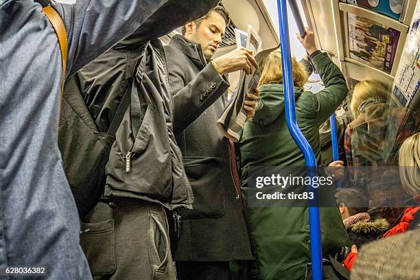 personen, die in einem überfüllten londoner u-bahn-zug unterwegs sind - busy tube stock-fotos und bilder