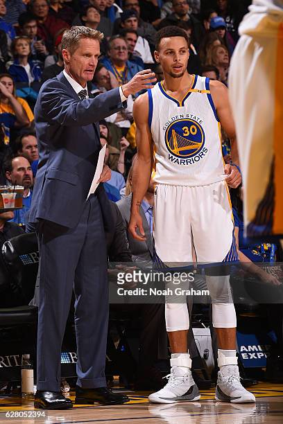 Steve Kerr and Stephen Curry talk during the game against the Indiana Pacers on December 5, 2016 at ORACLE Arena in Oakland, California. NOTE TO...