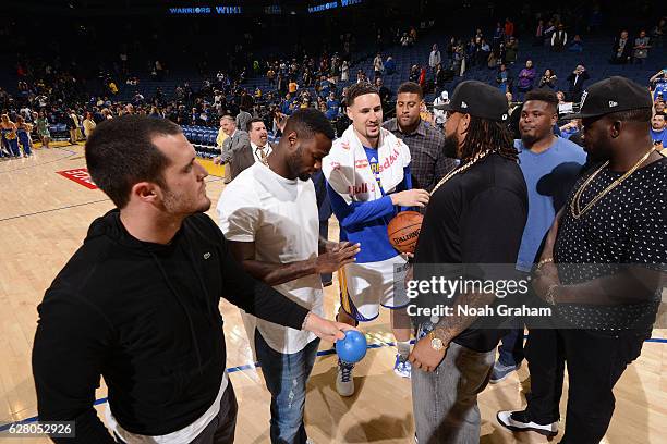 Klay Thompson of the Golden State Warriors talks to Oakland Raiders, Latavious Murray, Derek Carr and Donald Penn after the game against the Indiana...