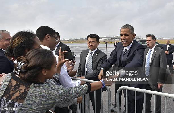 President Barack Obama greets well-wishers upon arrival at Tampa International Airport in Tampa, Florida on December 6, 2016. / AFP / Mandel Ngan