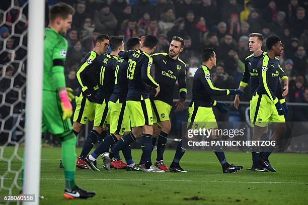 Arsenal's players celebrate after Arsenal's Spanish forward Lucas Perez scored a goal during the UEFA Champions league Group A football match between...