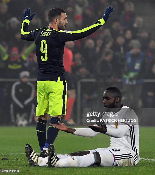 Arsenal's Spanish forward Lucas Perez celebrates after scoring a goal as Basel's Colombian defender Eder Balanta reacts during the UEFA Champions...