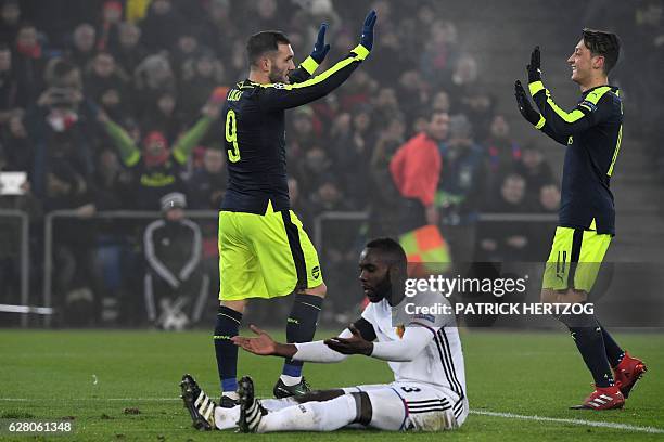 Arsenal's Spanish forward Lucas Perez celebrates after scoring a goal with his teammate Arsenal's German midfielder Mesut Ozil , next to Basel's...